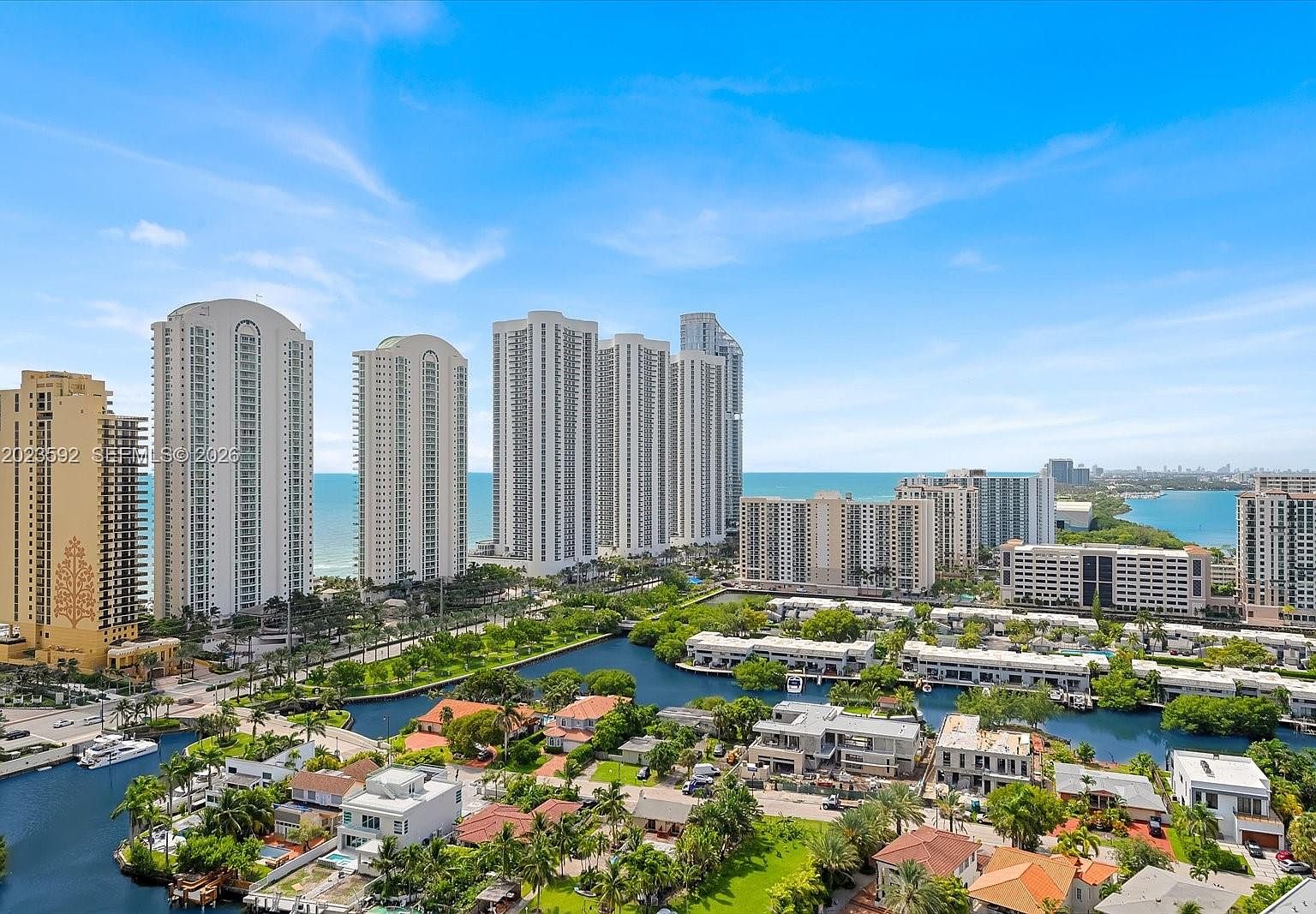 Aerial photograph of Sunny Isles Beach showing Trump International Beach Resort, the Atlantic, the intracoastal waterway, and the downtown Miami skyline beyond.