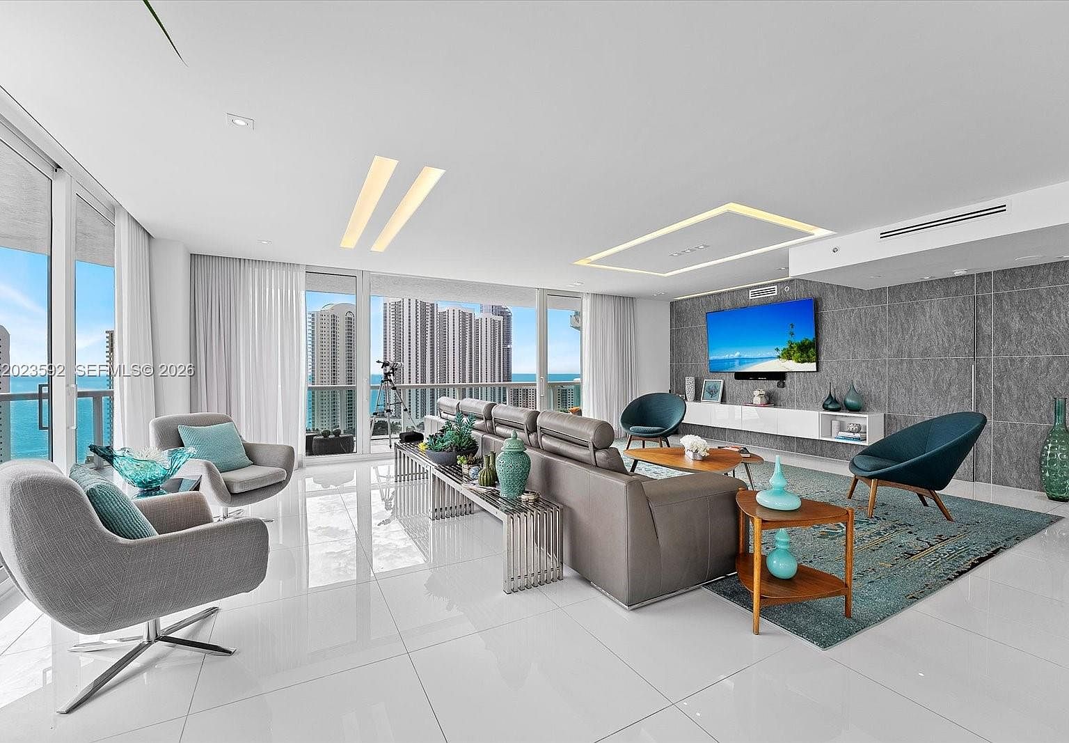 Wider view of the living room showing floor-to-ceiling glass on multiple sides and the wrap-around exposure of residence 2451.