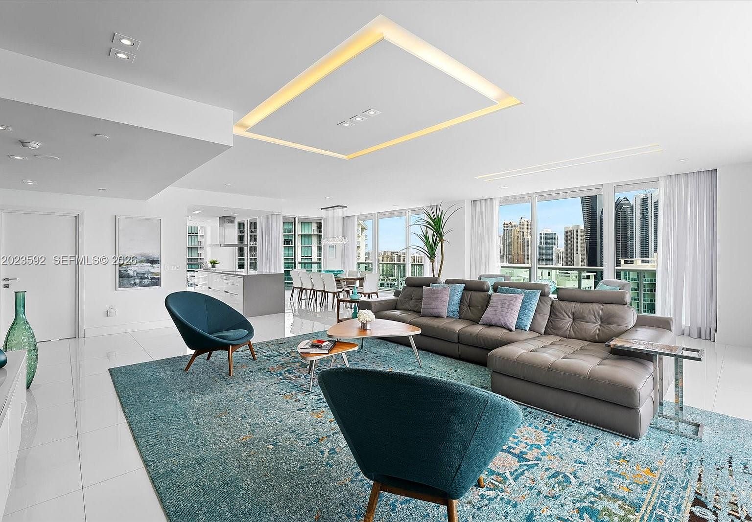 Living and dining looking west toward the intracoastal and the downtown Miami skyline at golden hour.